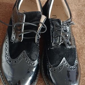 Pair of black patent leather shoes.  Wingtip design.  Lace-up closure.  Size 34.